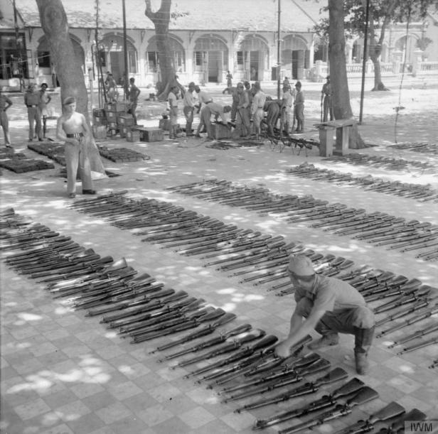 British-officers-watch-as-Japanese-prisoners-of-war-clean-and-oil-the-thousands-of-surrendered-Arisaka-rifles-at-the-prisoner-of-war-camp-at-Cape-Saint-Jacques (1)